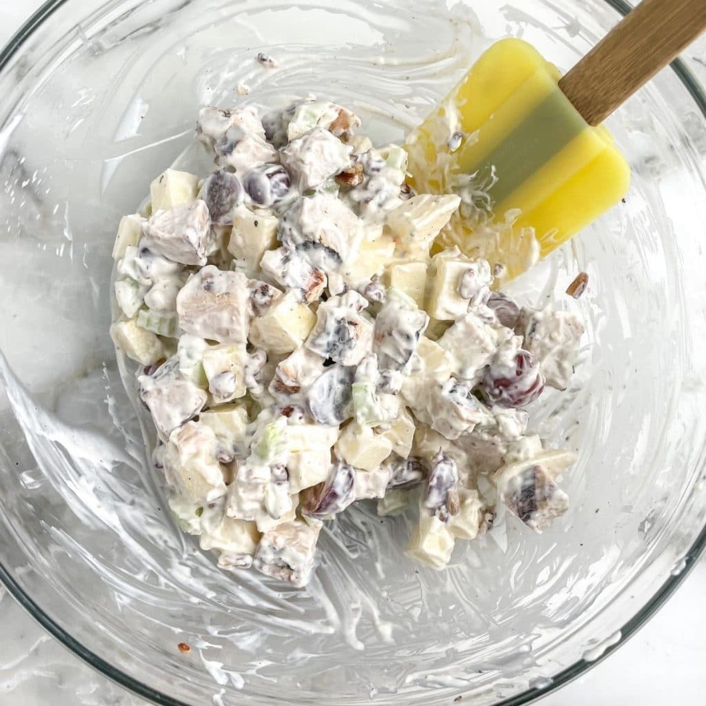 Bowl of chicken salad with a spatula.