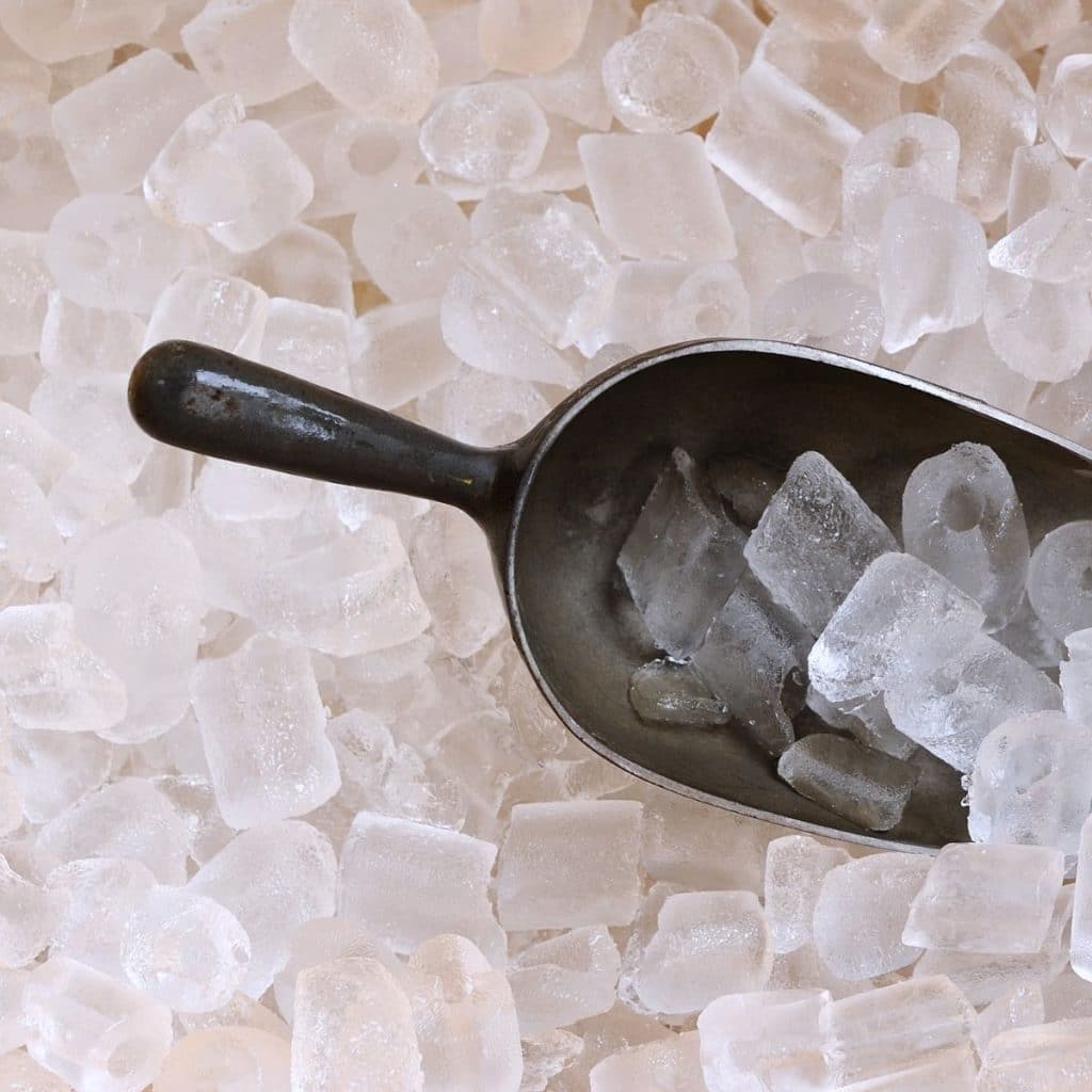 Bunch of ice cubes with a scoop. 