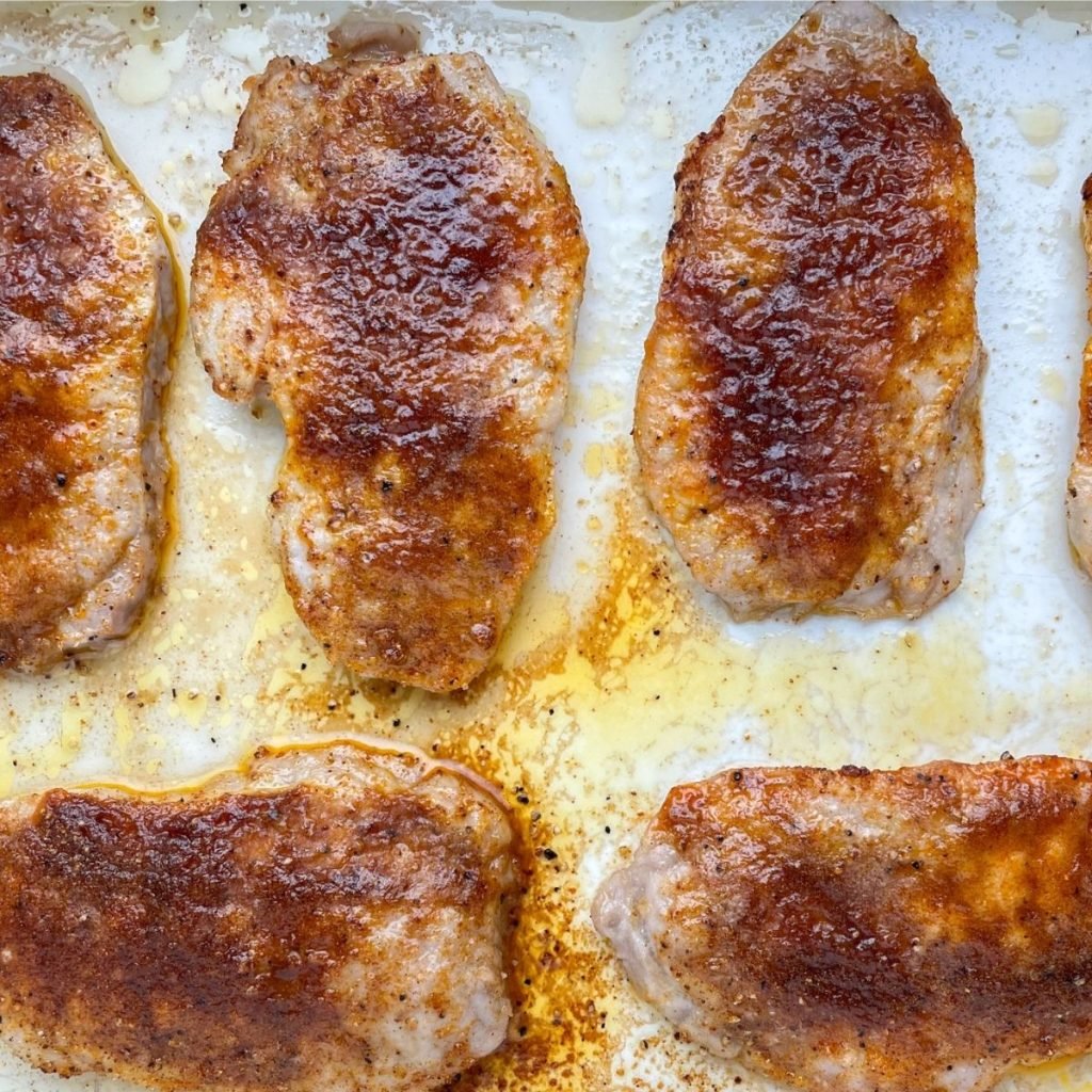 Baked pork chops in a baking dish.