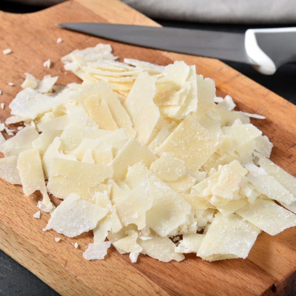Shaved cheese on a cutting board.