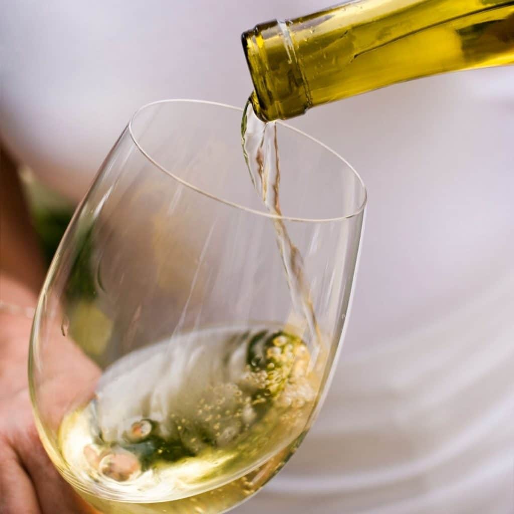 White wine pouring into glass.