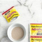 Bowl of yeast and a yeast packet.