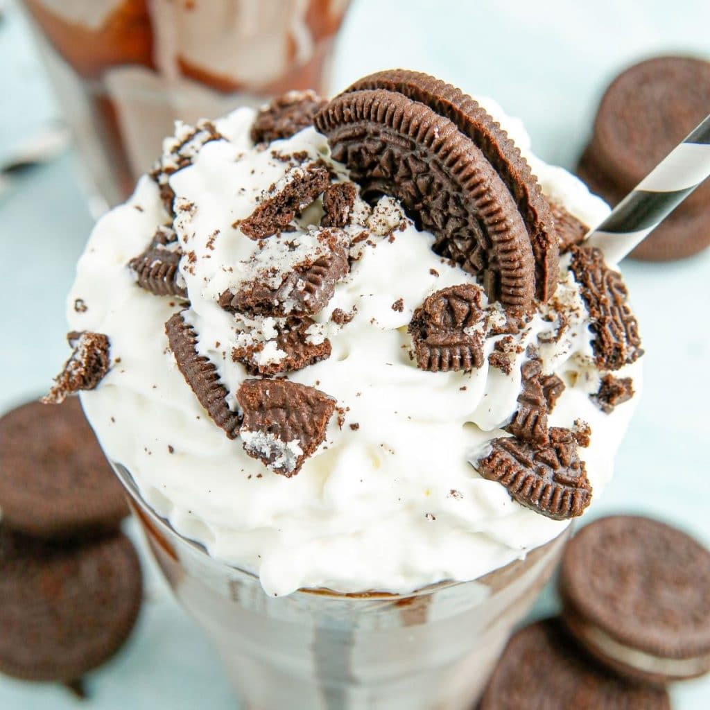 Milkshake topped with whipped cream and Oreo cookies.