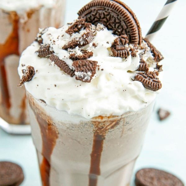 Glass filled with Oreo milkshake and a straw.