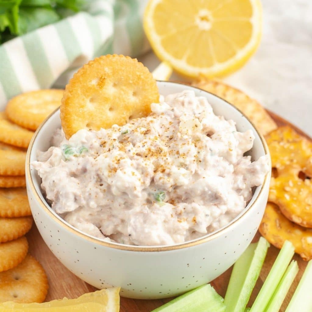 Bowl of dip with Ritz cracker in it. 