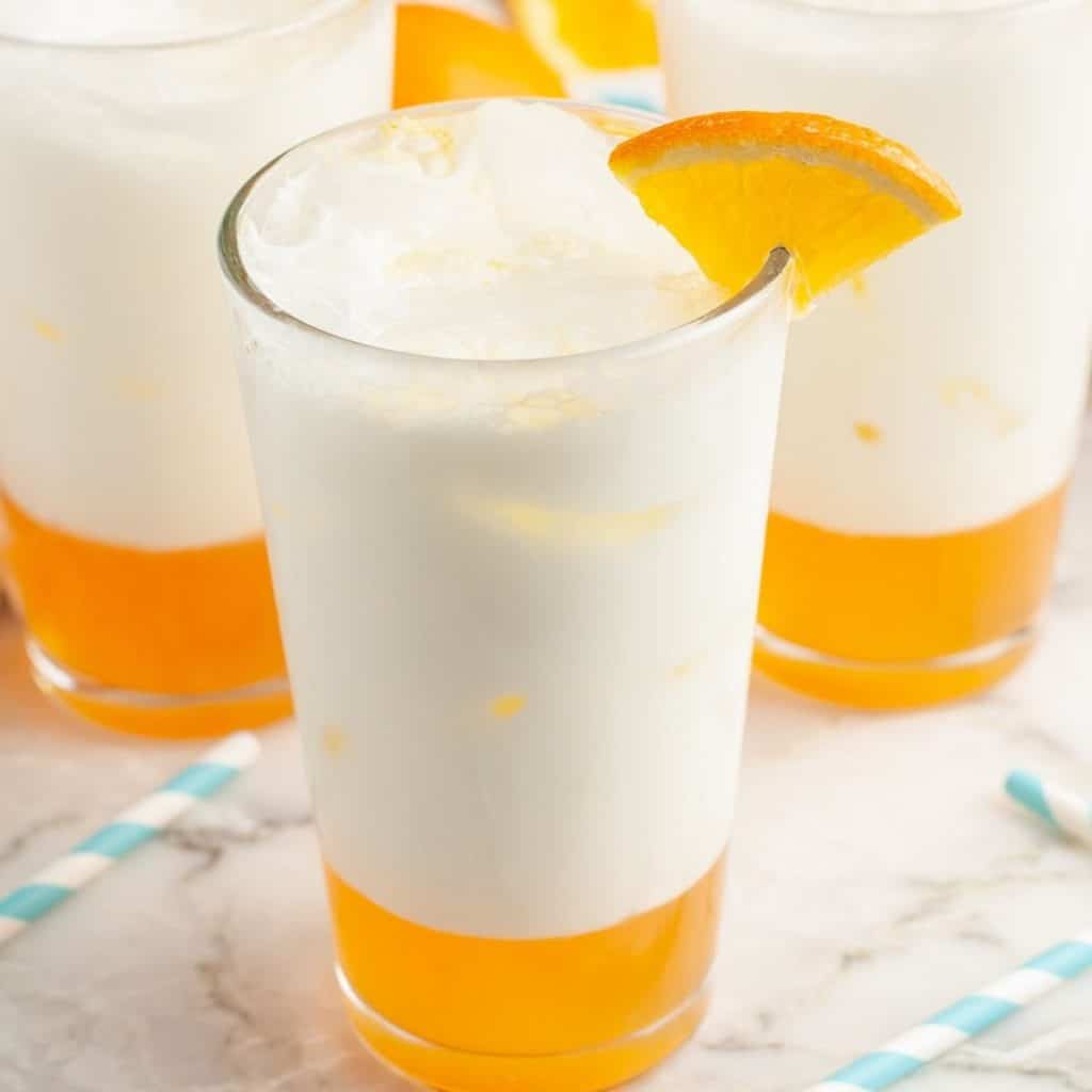 Glass with orange soda and cream.