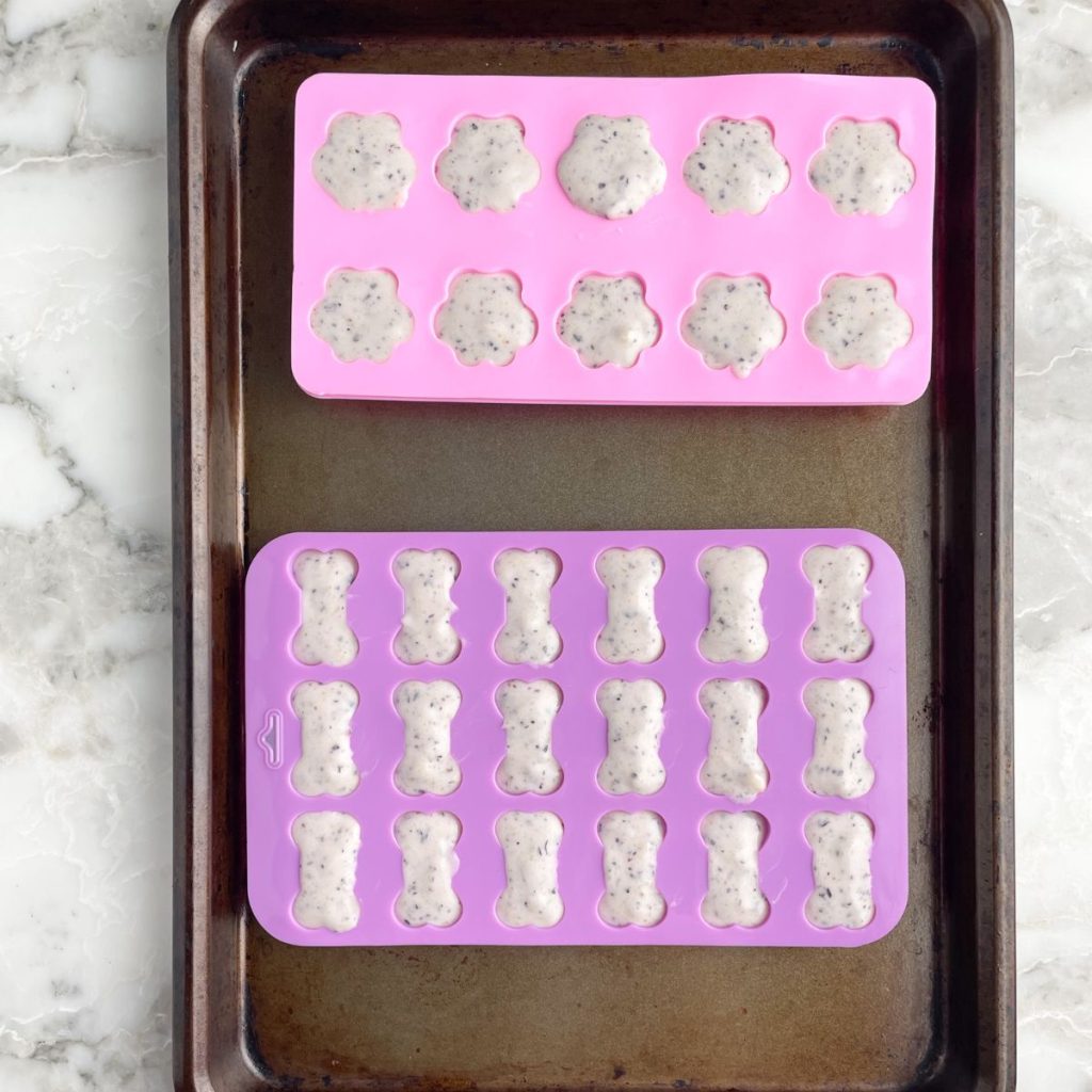 Filled silicone molds on a baking sheet. 