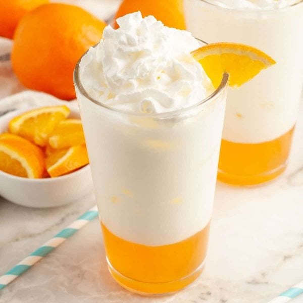 Glass of orange cream soda with orange slice.