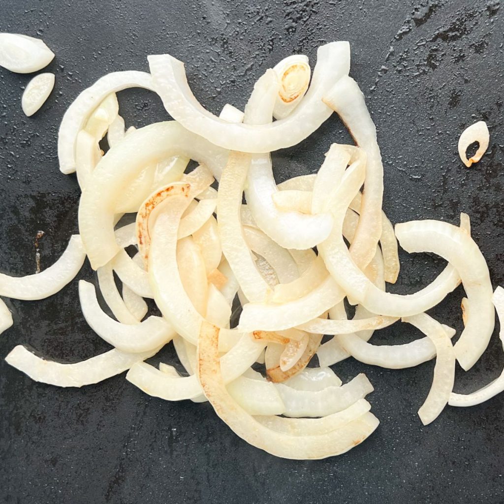 Cooked onions on a griddle.