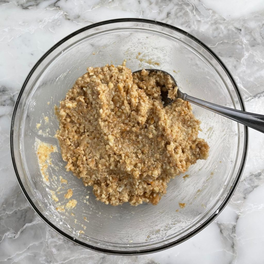 Bowl with cookie crumbs and spoon.