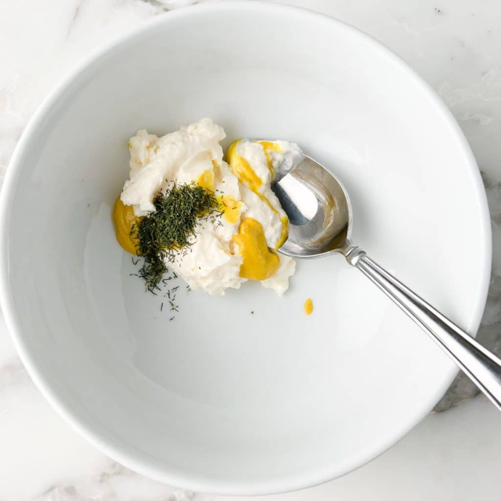 Bowl with mayonnaise, mustard, and dill.