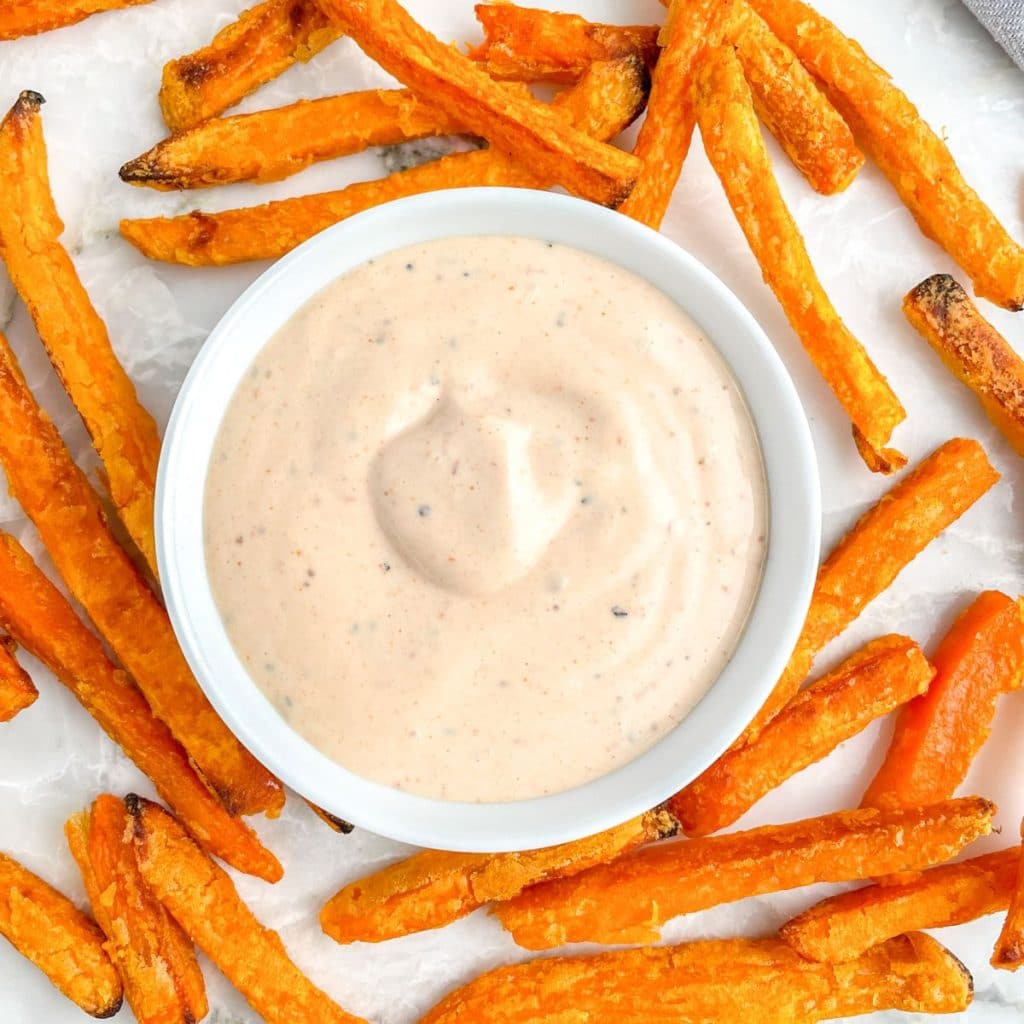 Bowl of sauce with sweet potato fries. 