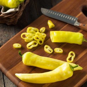 Banana peppers on a cutting board.