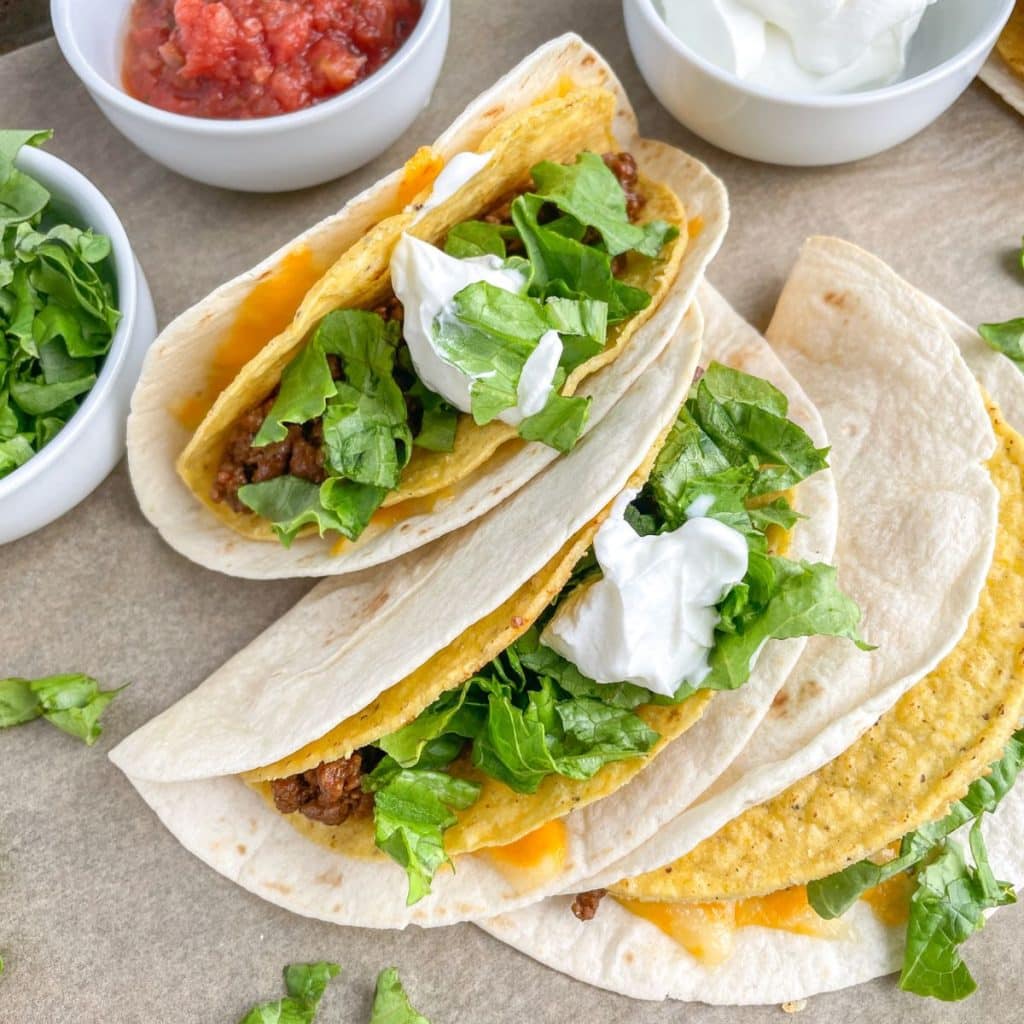 Three gorditas and bowl of salsa and sour cream. 