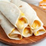 Plate of tortilla roll ups with cheese.