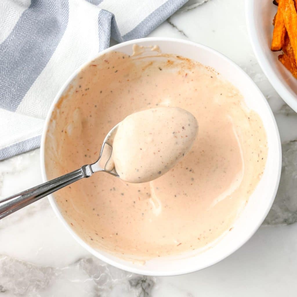 Spoon in a bowl of mayonnaise sauce.