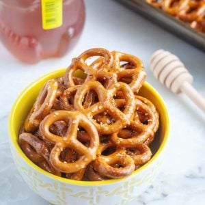 Bowl of small pretzels and bottle of honey.