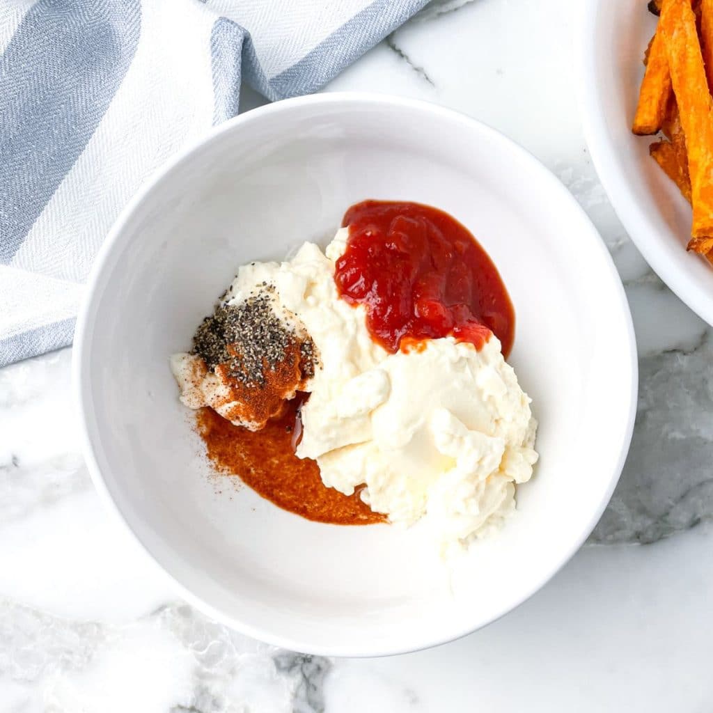 Bowl with mayo, chili sauce, and seasonings. 