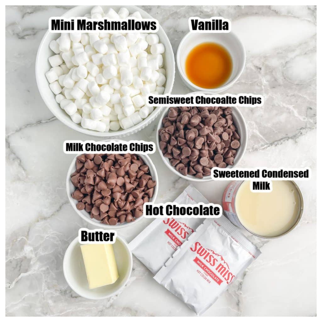 Bowl of marshmallows, chocolate chips, butter, vanilla, sweetened condensed milk, and hot chocolate packs.