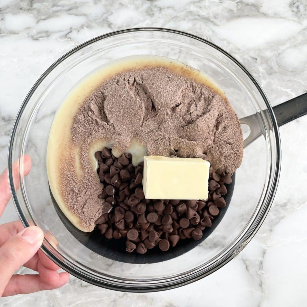 Bowl filled with butter, chocolate chips, and cocoa powder.