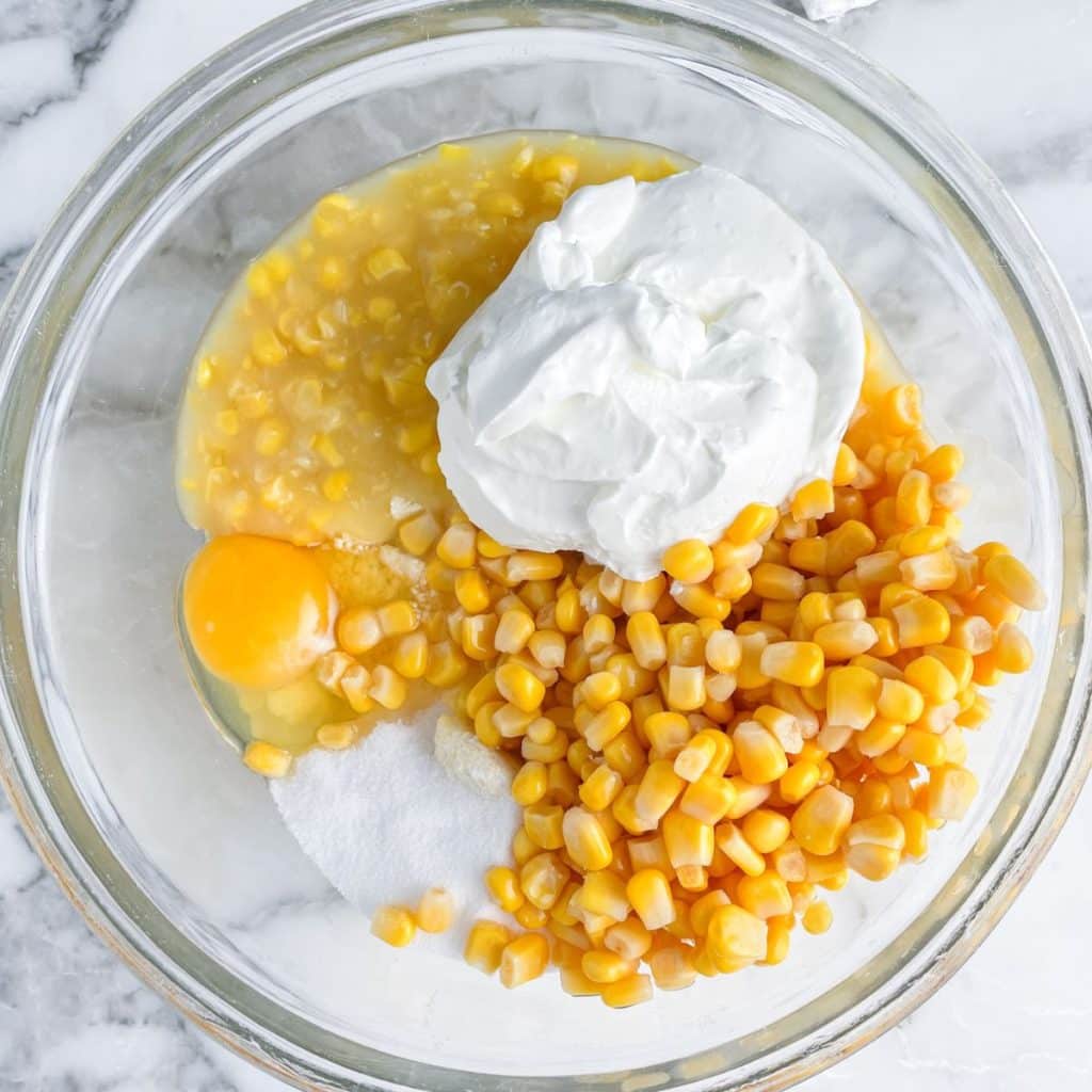 Bowl with sour cream, corn, egg, and sugar. 