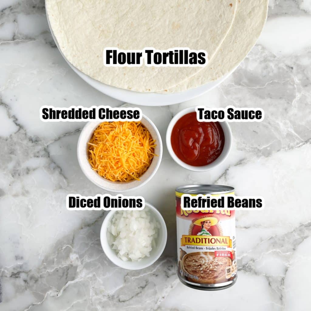 Tortillas, bowl of shredded cheese, sauce, diced onion, and can of beans.