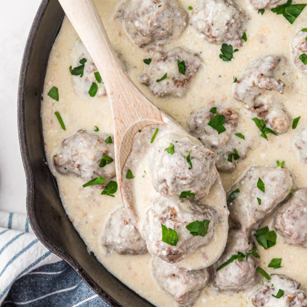 Cast iron skillet with meatballs in cream sauce. 