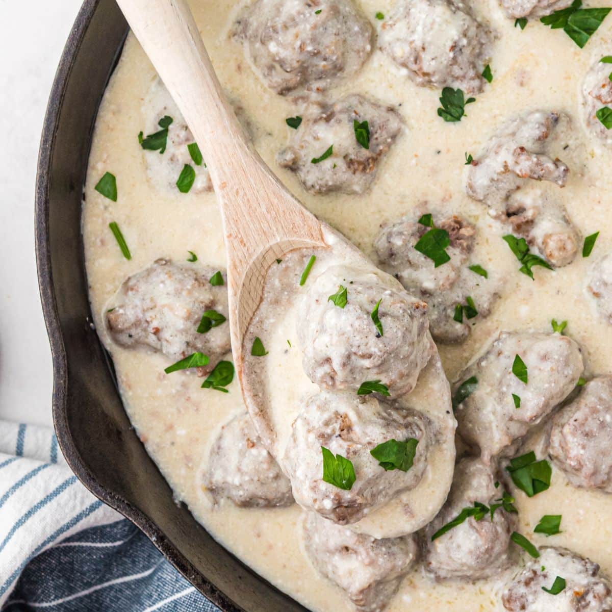 Cast iron skillet with meatballs in cream sauce.