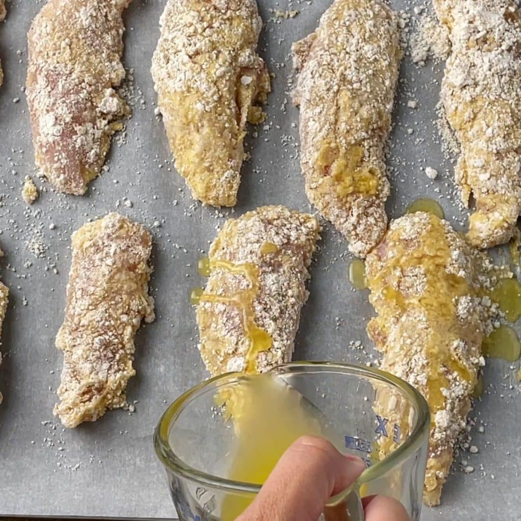 Melted butter pouring over chicken tenders. 