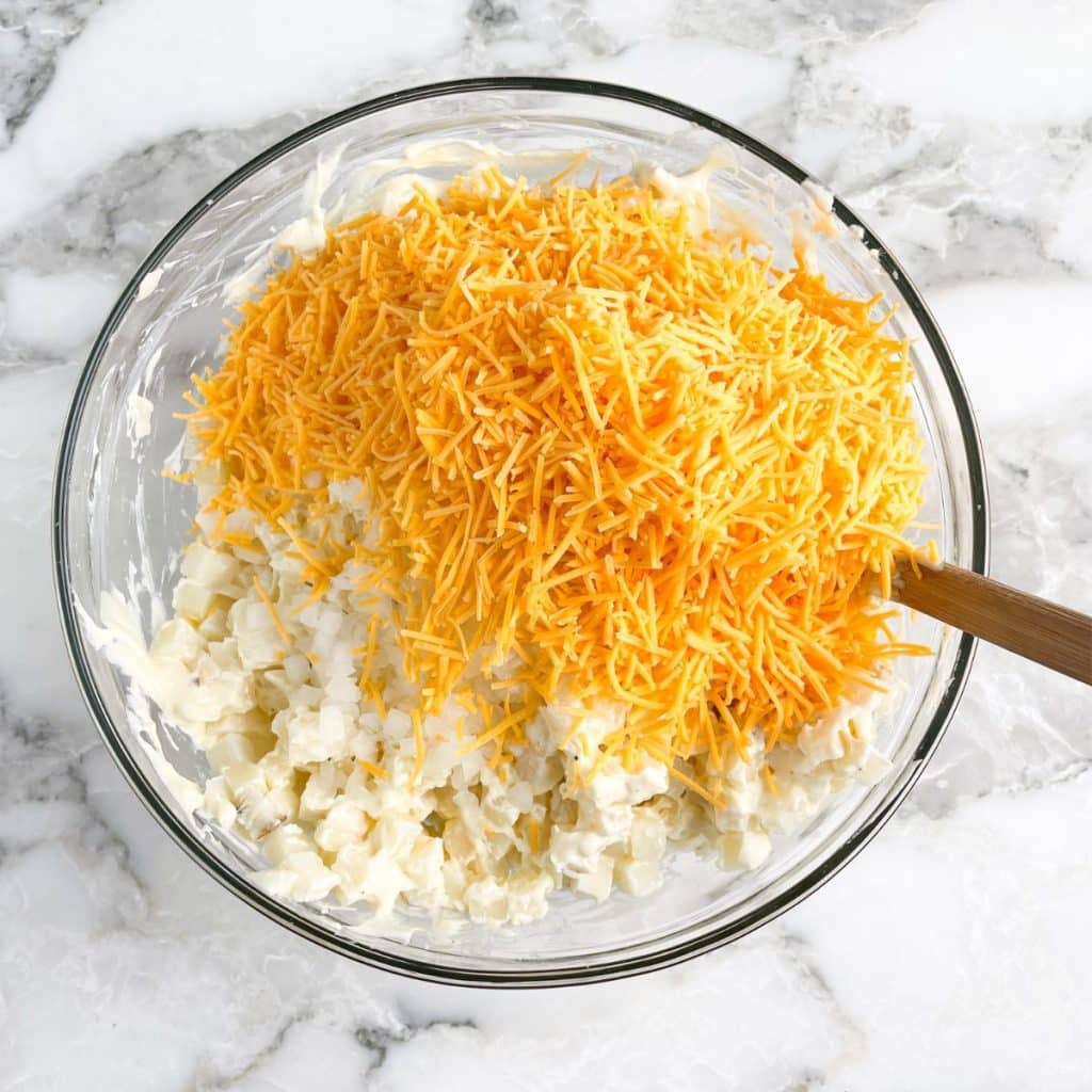 Bowl with hash browns and shredded cheese.