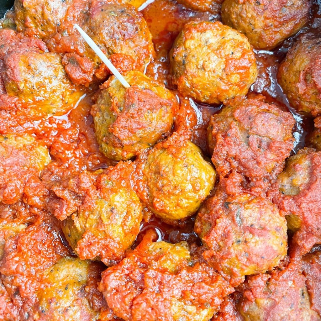 Meatballs in sauce with a toothpick. 