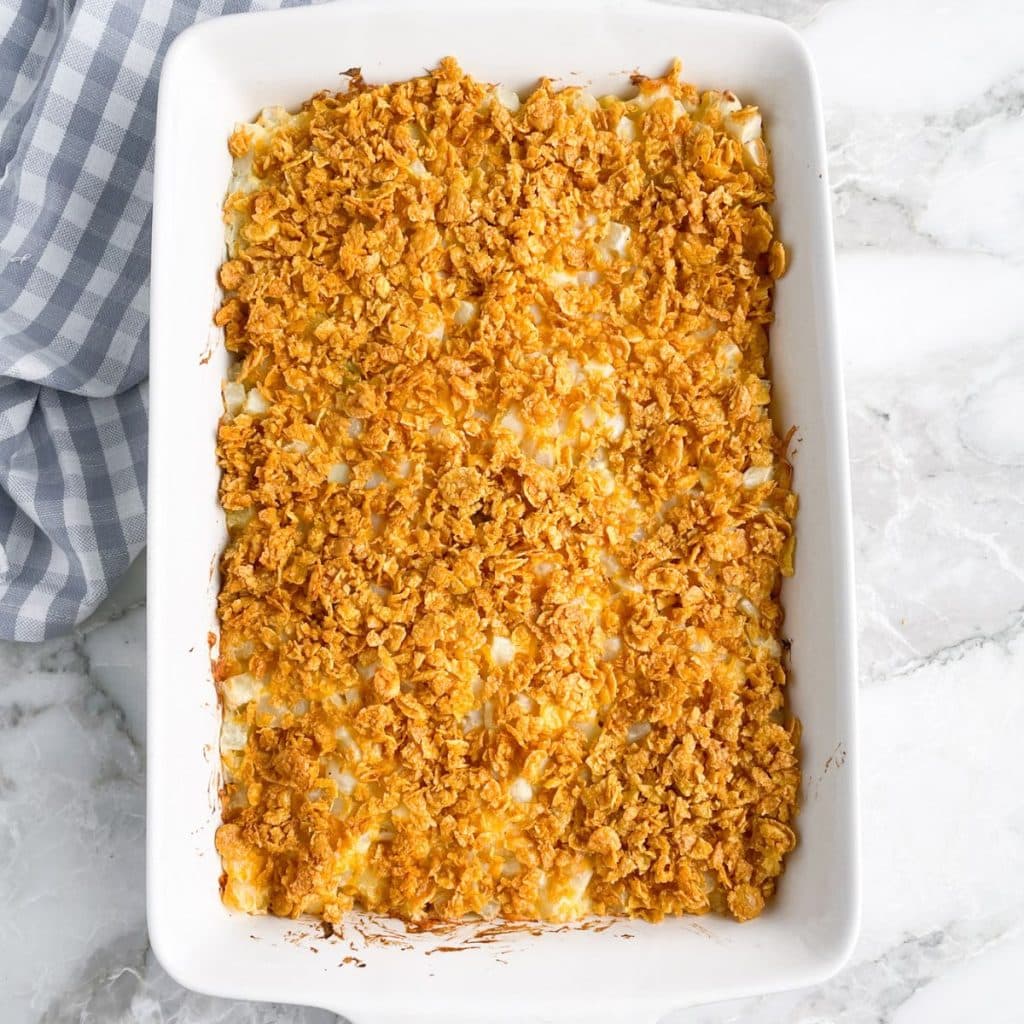 Casserole dish with potato casserole topped with corn flakes.