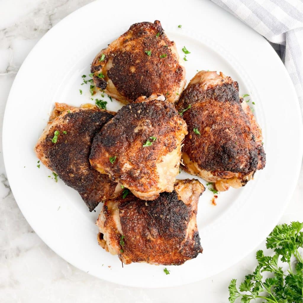 Baked chicken thighs on a plate.