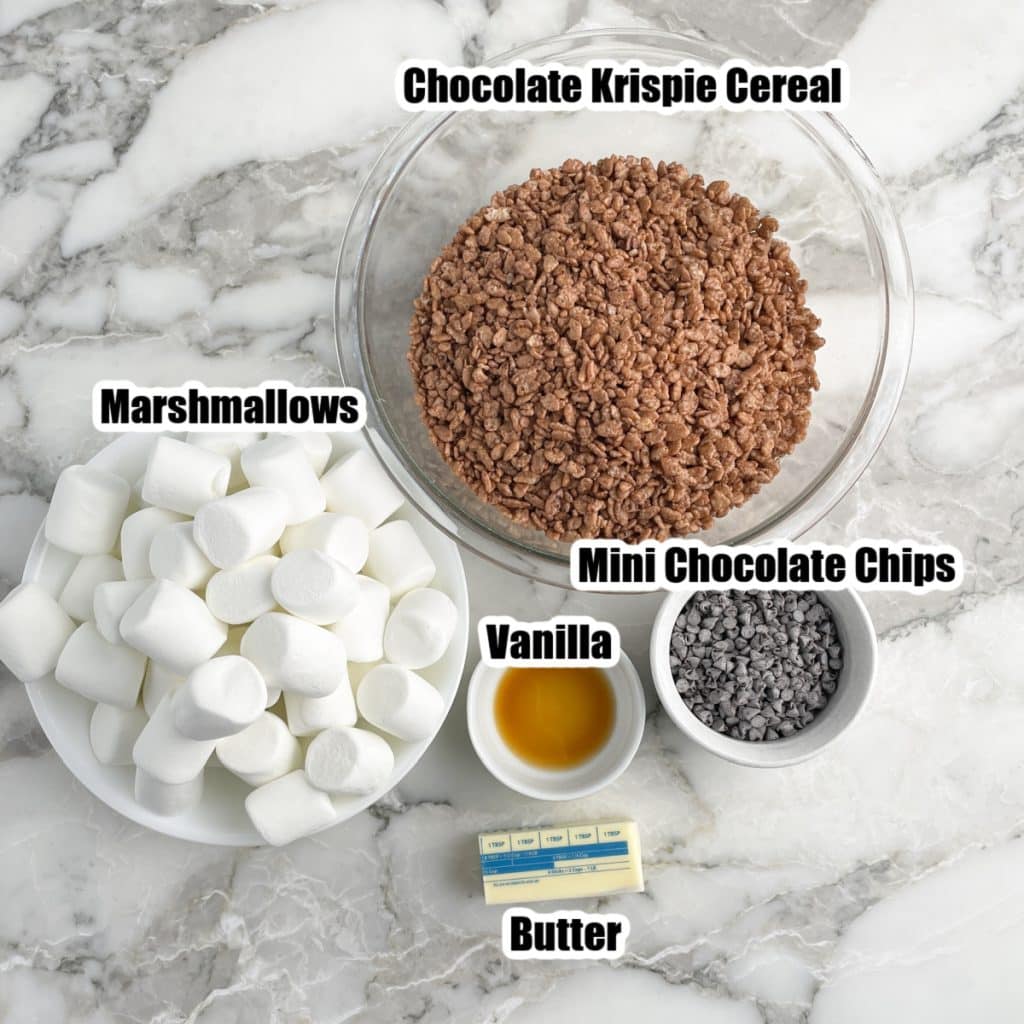 Bowl of large marshmallows, mini chocolate chips, butter, and chocolate rice krispie cereal.