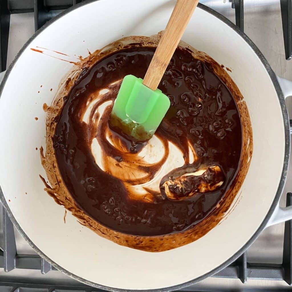 Saucepan with melted chocolate and a spatula.