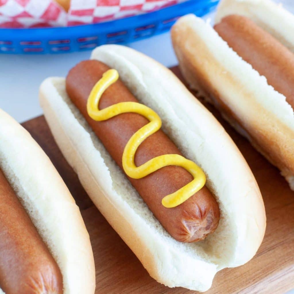 Hot dogs in a bun with mustard.