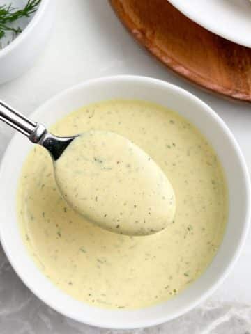 Bowl of yellow sauce and a spoon.
