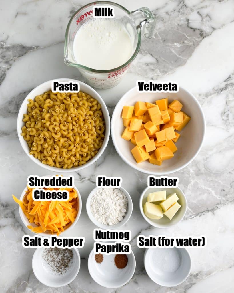 Bowl of milk, elbow pasta, Velveeta, cheese, flour, butter, and spices. 