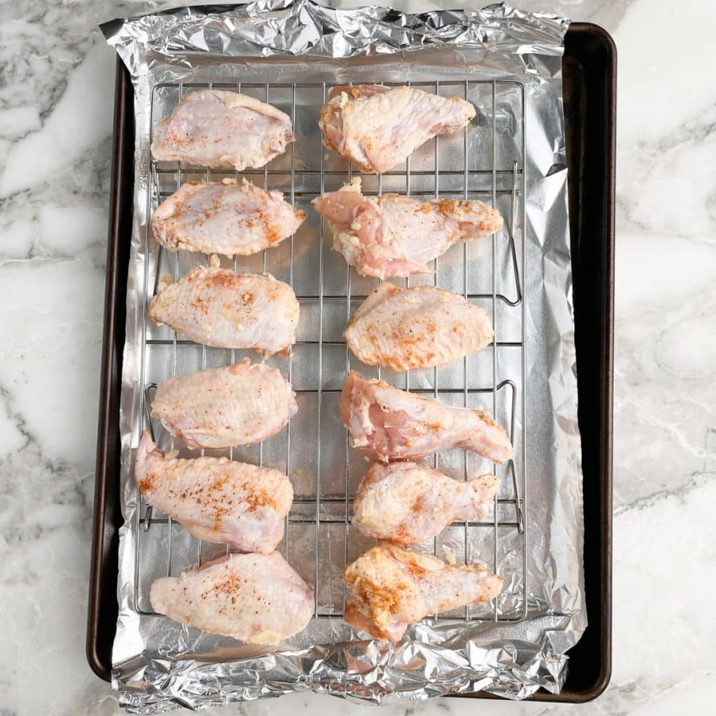 Uncooked chicken wings on a baking sheet.
