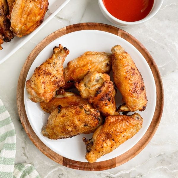 Plate of chicken wings and bowl of sauce.