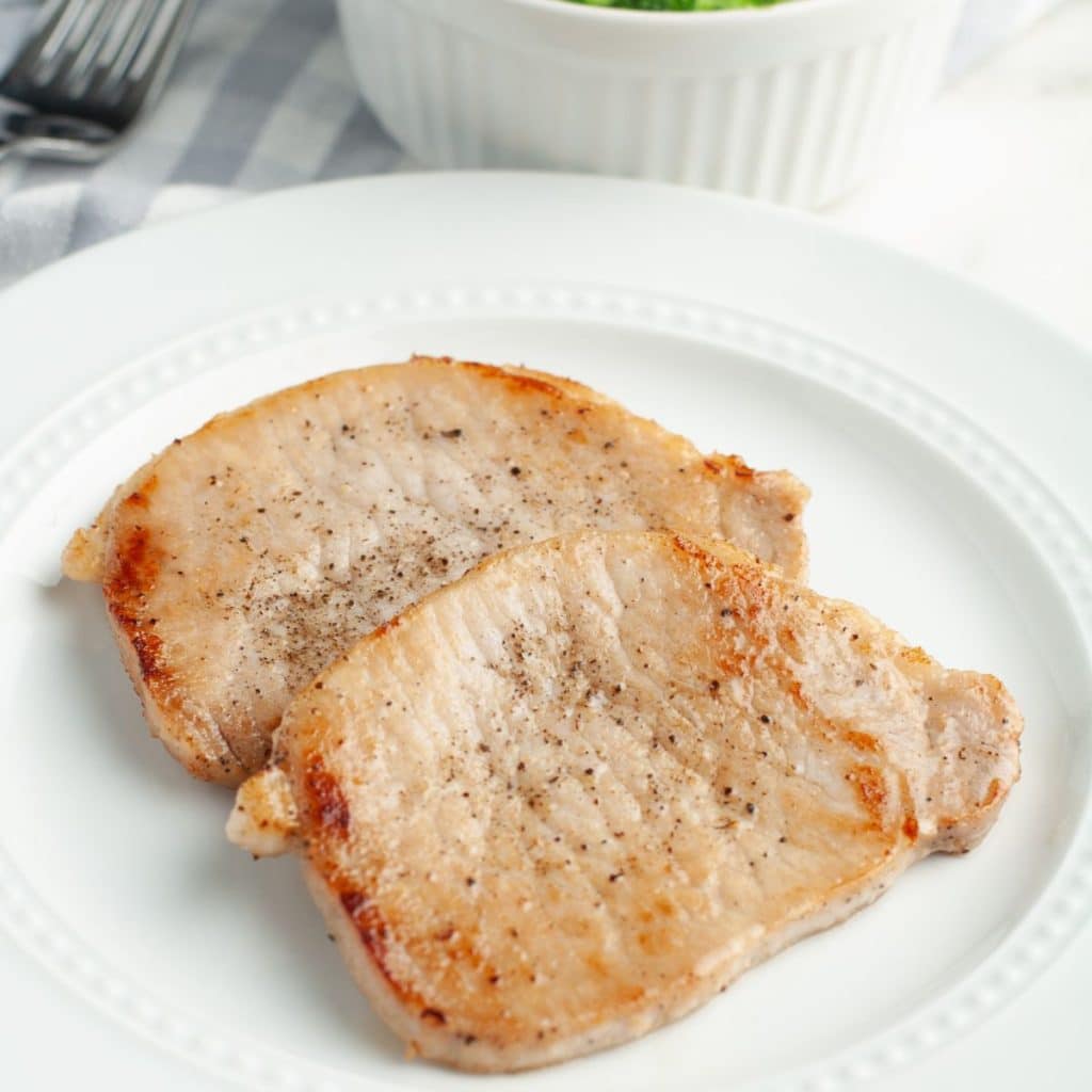 Thin pork chops on a plate.