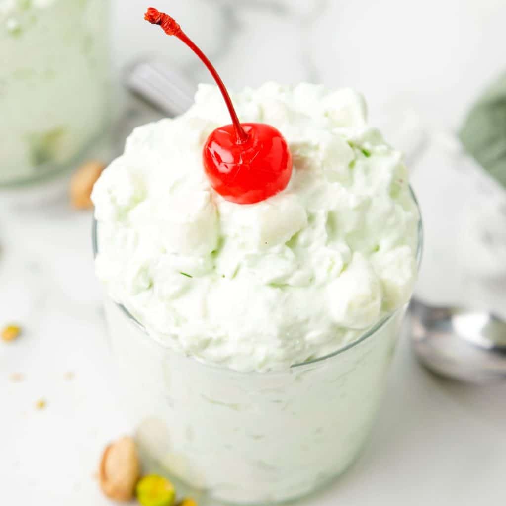 Cup of pistachio fluff with a cherry on top. 