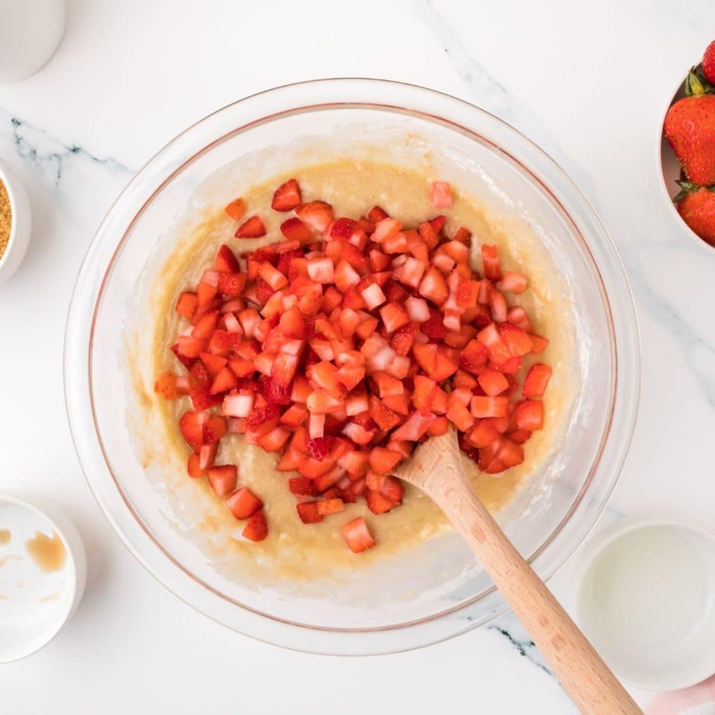 Bowl of batter with diced strawberries.