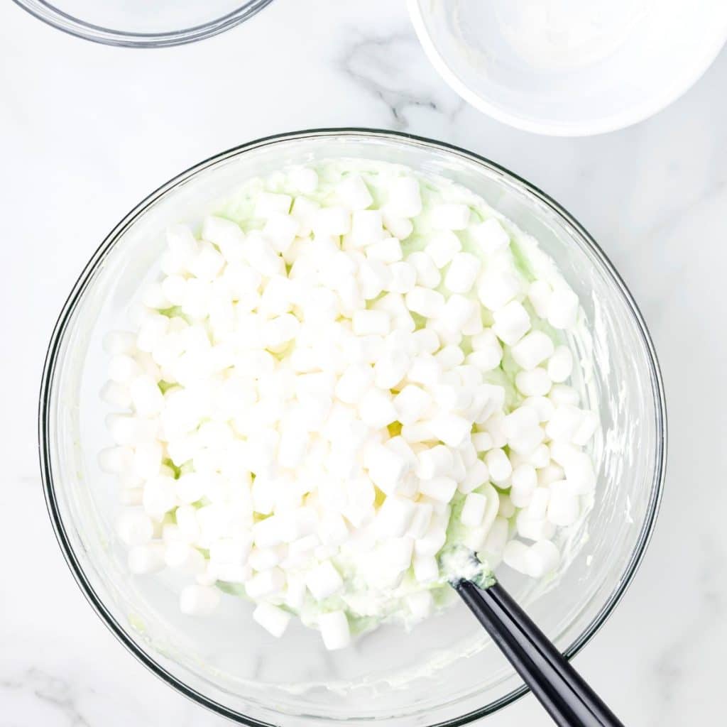 Bowl of mini marshmallows and green pudding. 