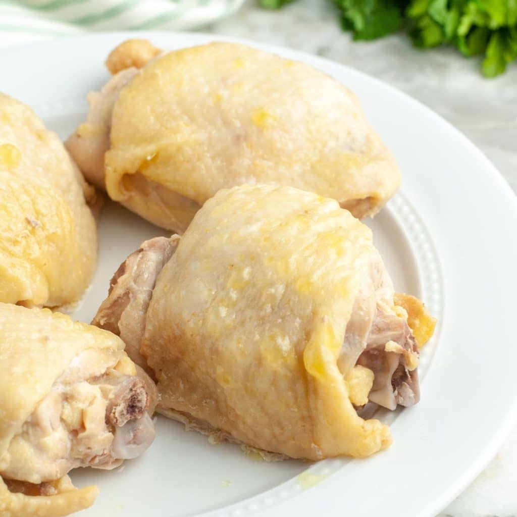 Boiled chicken thighs on a plate.