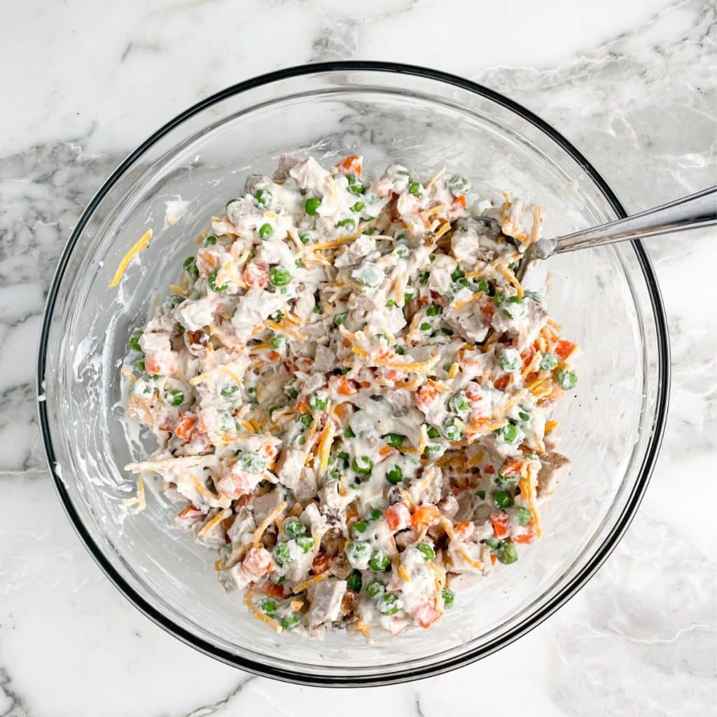 Bowl with pork, cream of mushroom soup, peas and carrots, and shredded cheese. 