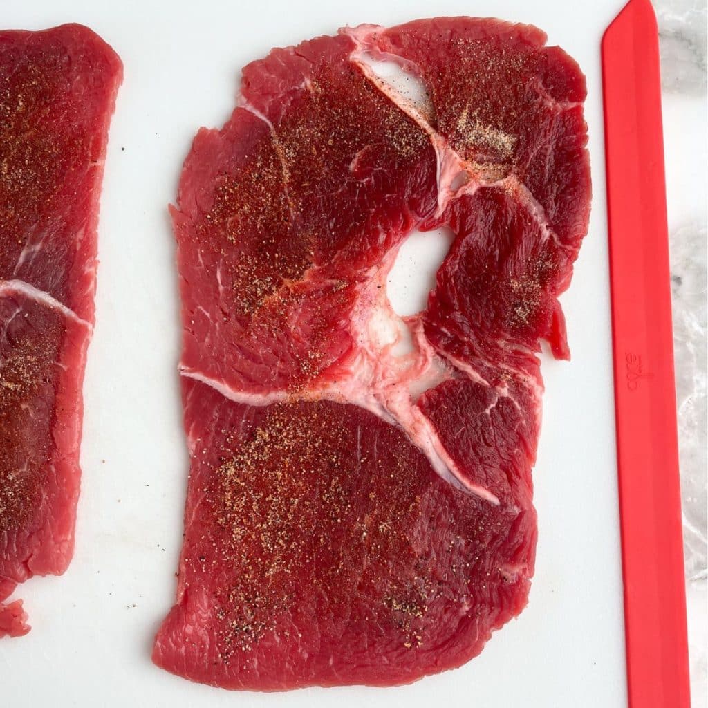 Uncooked steak with seasonings. 