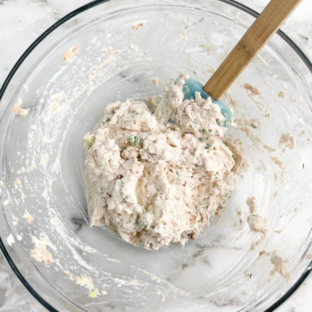 Bowl of salmon salad with a spatula. 