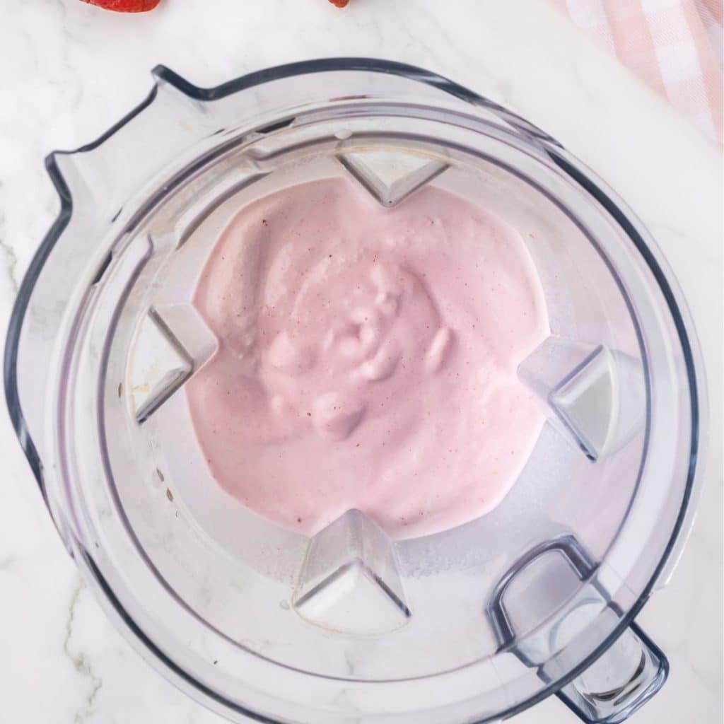 Blender with strawberry milkshake.