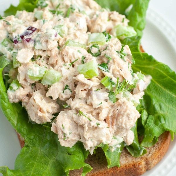 Salmon salad on a lettuce leaf and wheat bread.